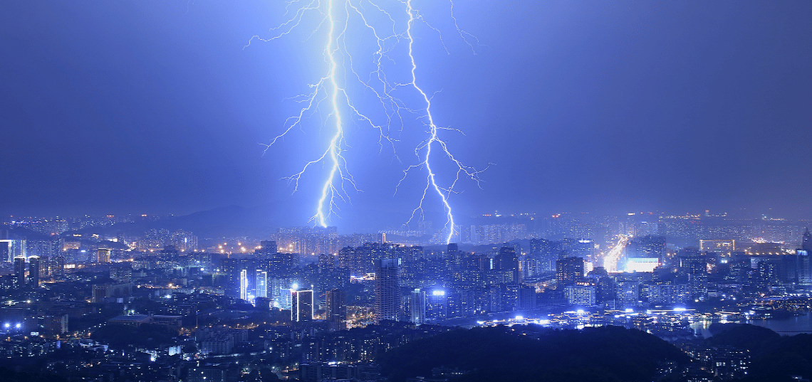 Lightning over a city during a storm, illustrating weather-related property damage claim guidance.