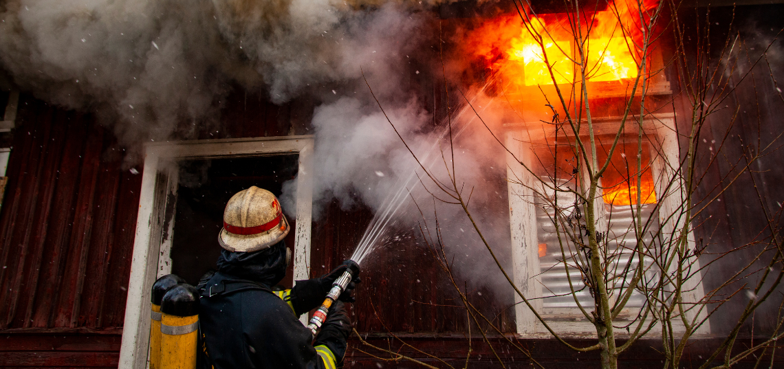 Smoke and flames inside a residential property after a fire, illustrating damage for an insurance claim.
