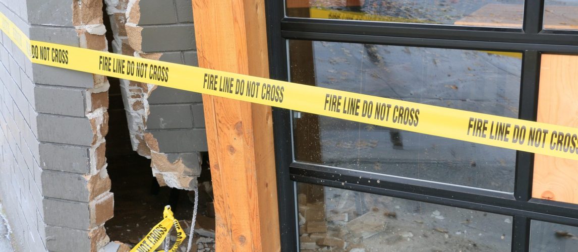 Residential property damage scene marked with caution tape in an article about what counts as property damage.