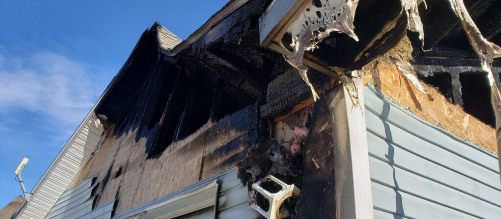 Burned roof structure illustrating fire damage that a public adjuster can document for an insurance claim.